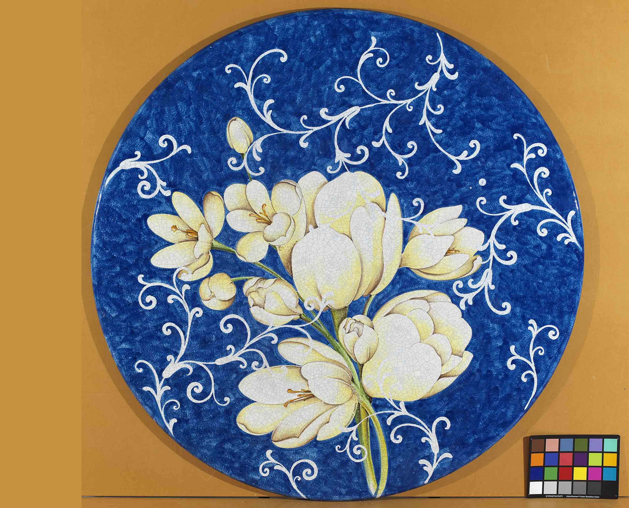 Birds eye view of the hand-painted Italian ceramic glaze Como Magnolie large white magnolia bouquet and fine white scrolls on a round volcanic stone tabletop