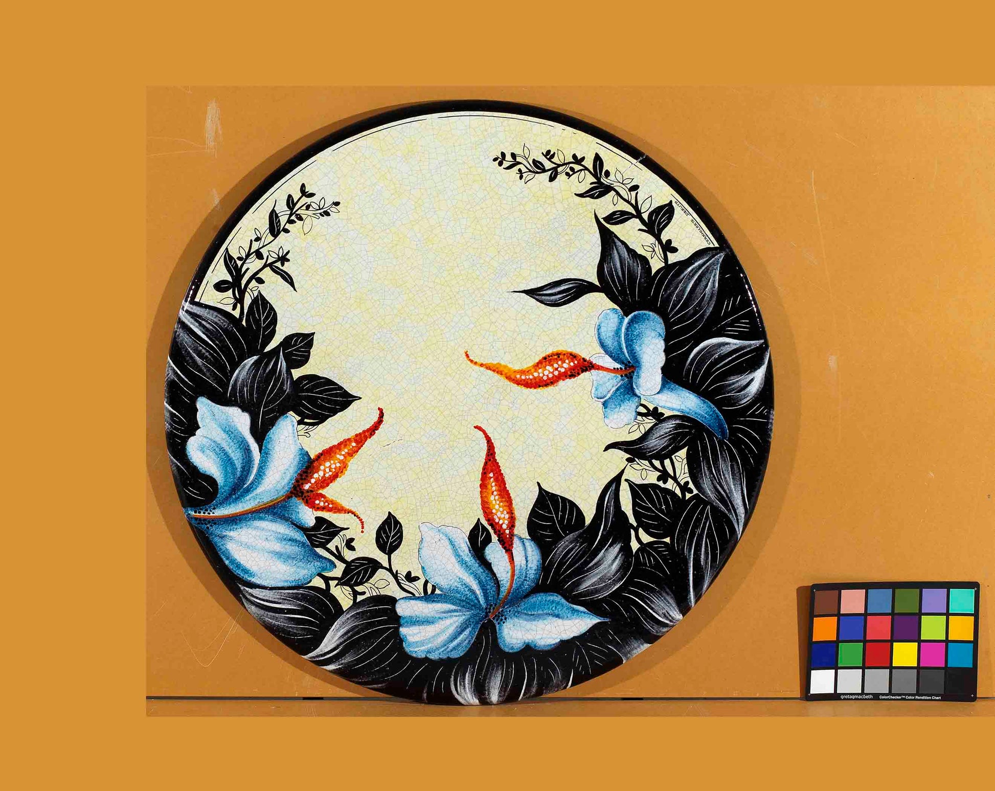 Birds eye view of the hand-painted Italian ceramic glaze Ischia Esotica exotic sky blue lilies and dramatic midnight black leaves on a round volcanic stone tabletop