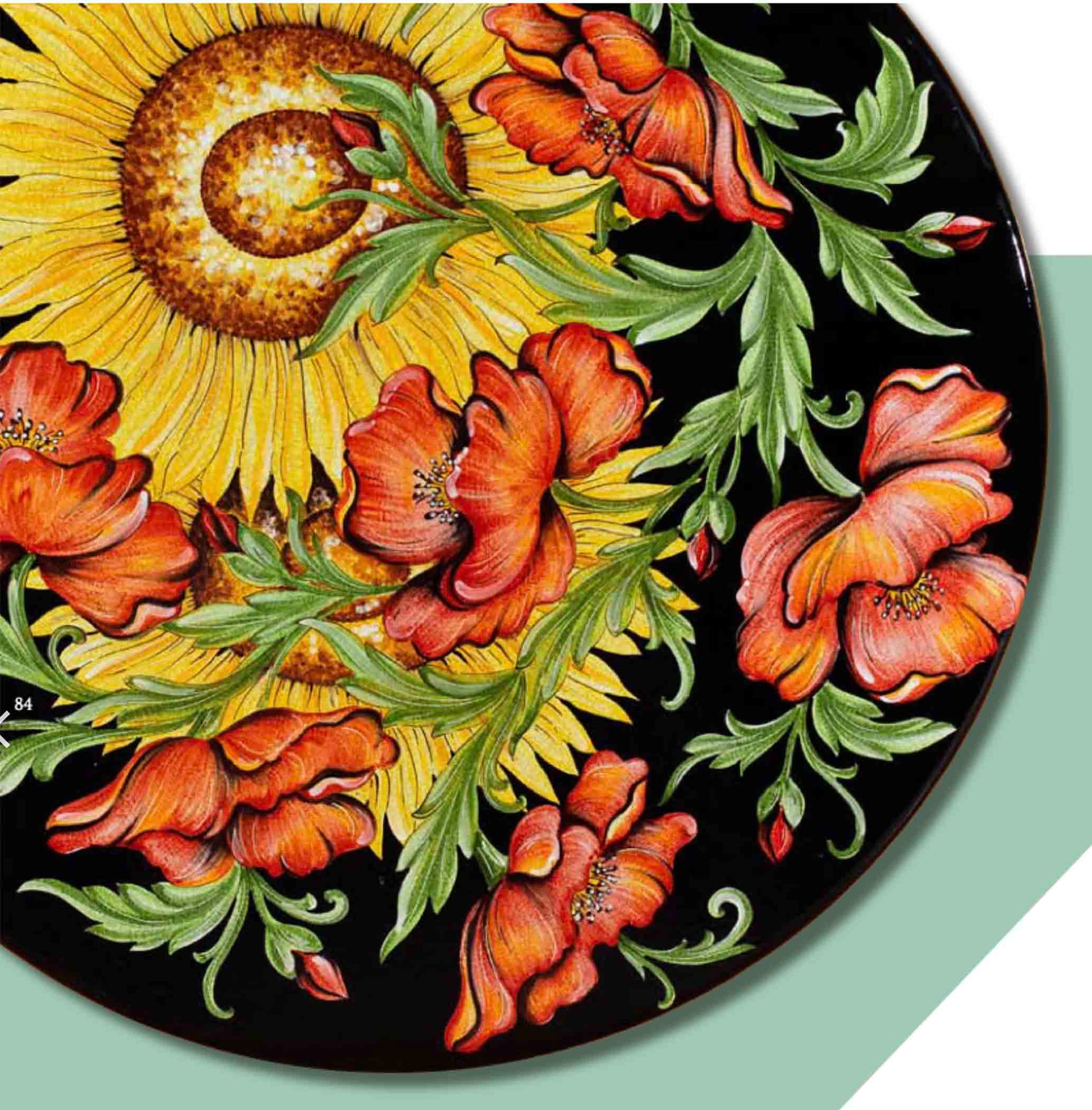 Close up detail of the intense black background glaze, multi-toned green acanthus leaves, and beautiful craquelé texture on the Lucca Campagna round volcanic stone table