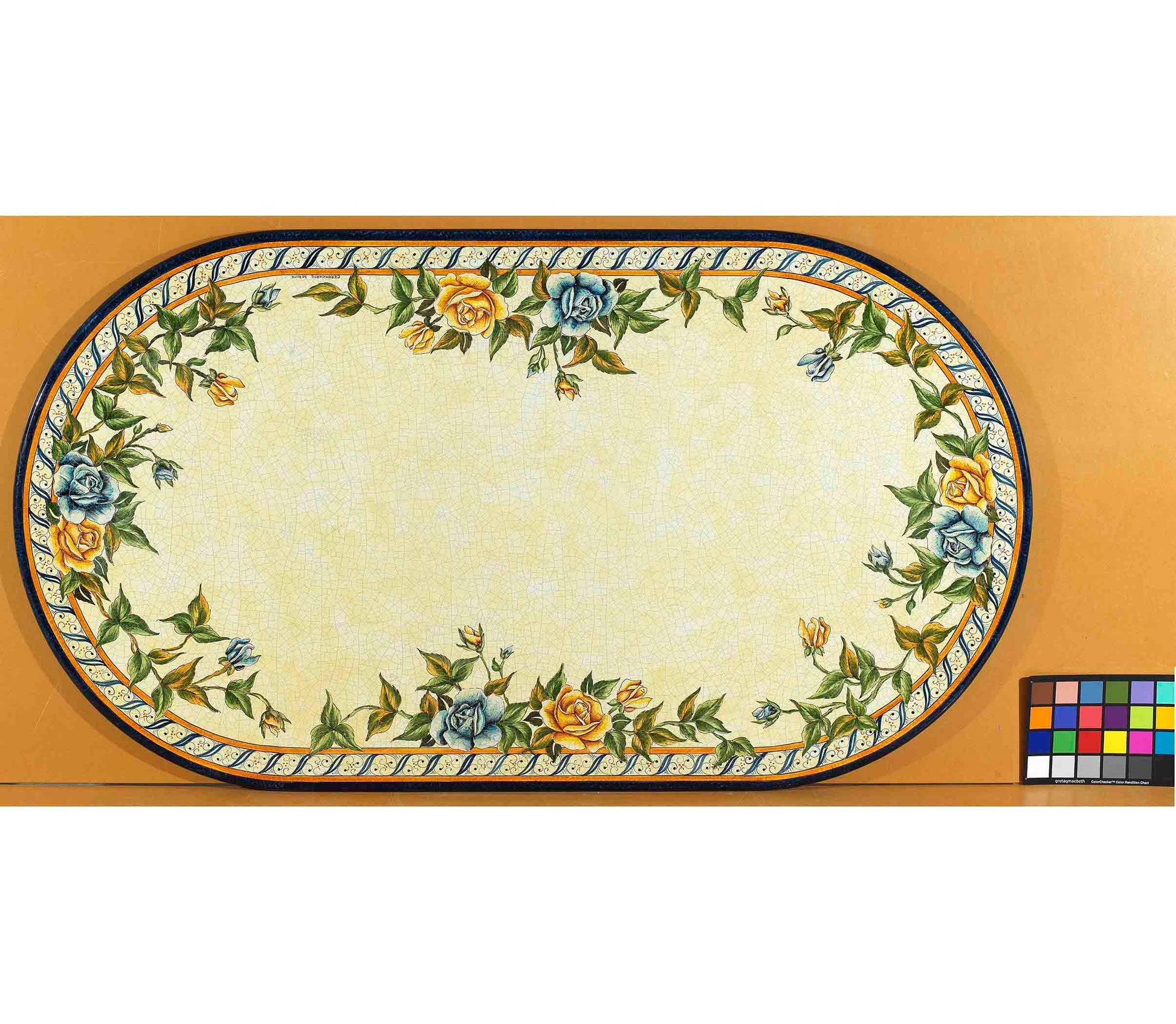 Birds eye view of the hand-painted Italian ceramic glaze Bellagio Fiorito trailing floral perimeter and rope-twist border on an oval volcanic stone tabletop