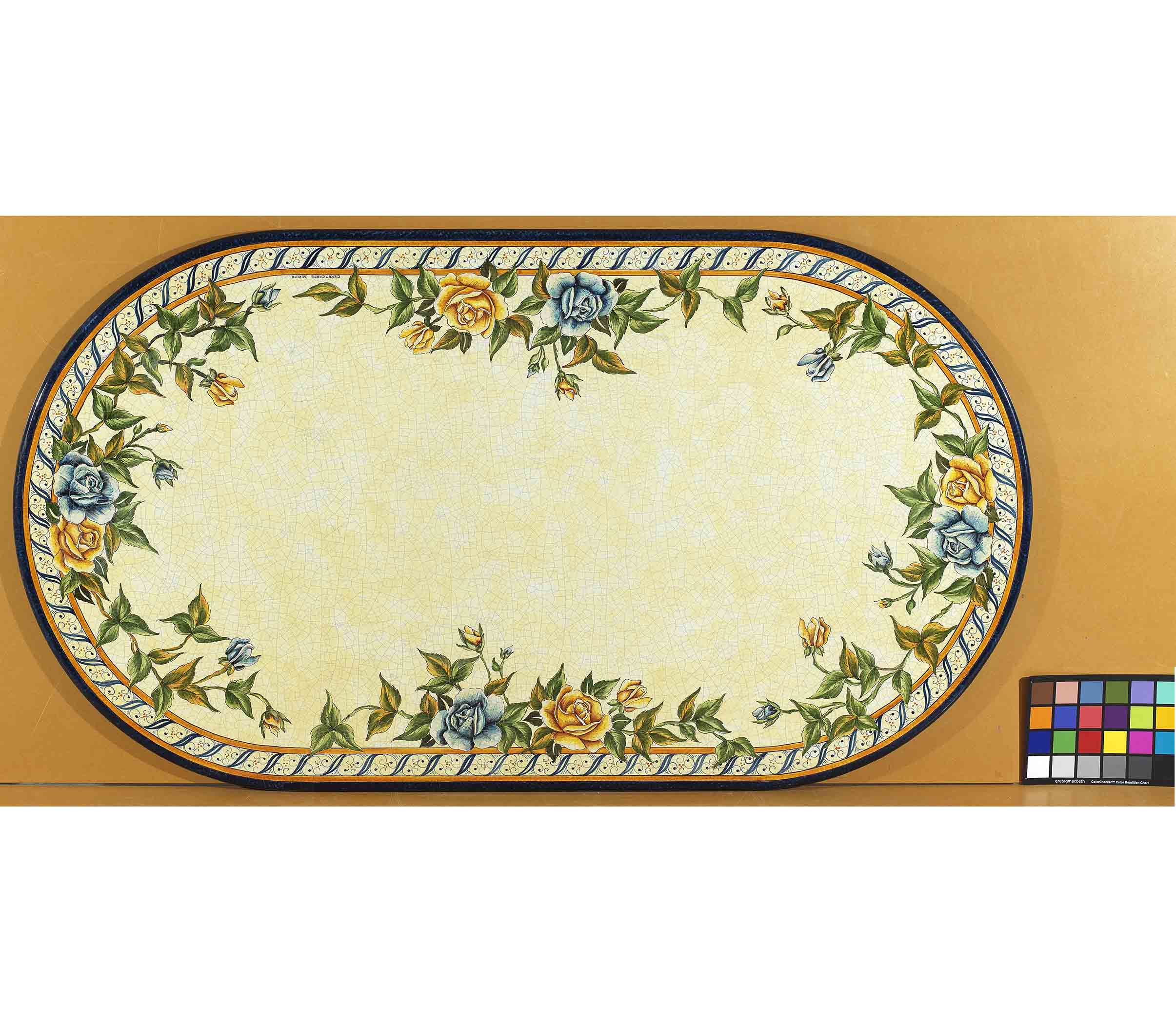 Birds eye view of the hand-painted Italian ceramic glaze Bellagio Fiorito trailing floral perimeter and rope-twist border on an oval volcanic stone tabletop