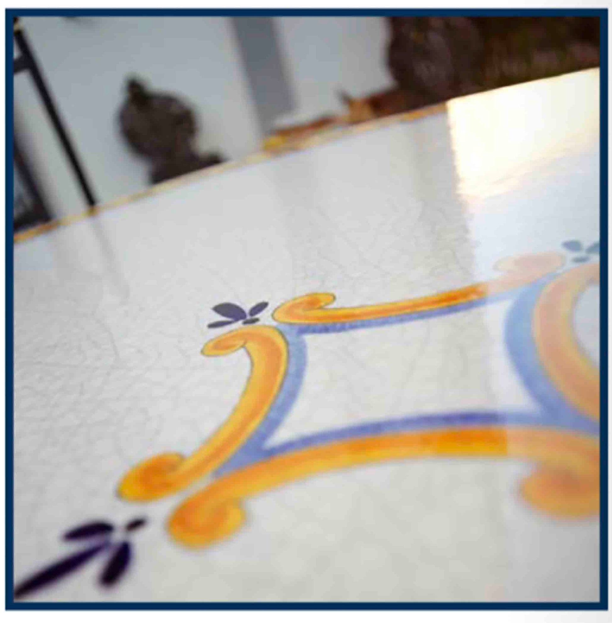 Close up detail of the open ivory crackle background glaze and fine blue and yellow central star details on the Palermo Classico round volcanic stone table