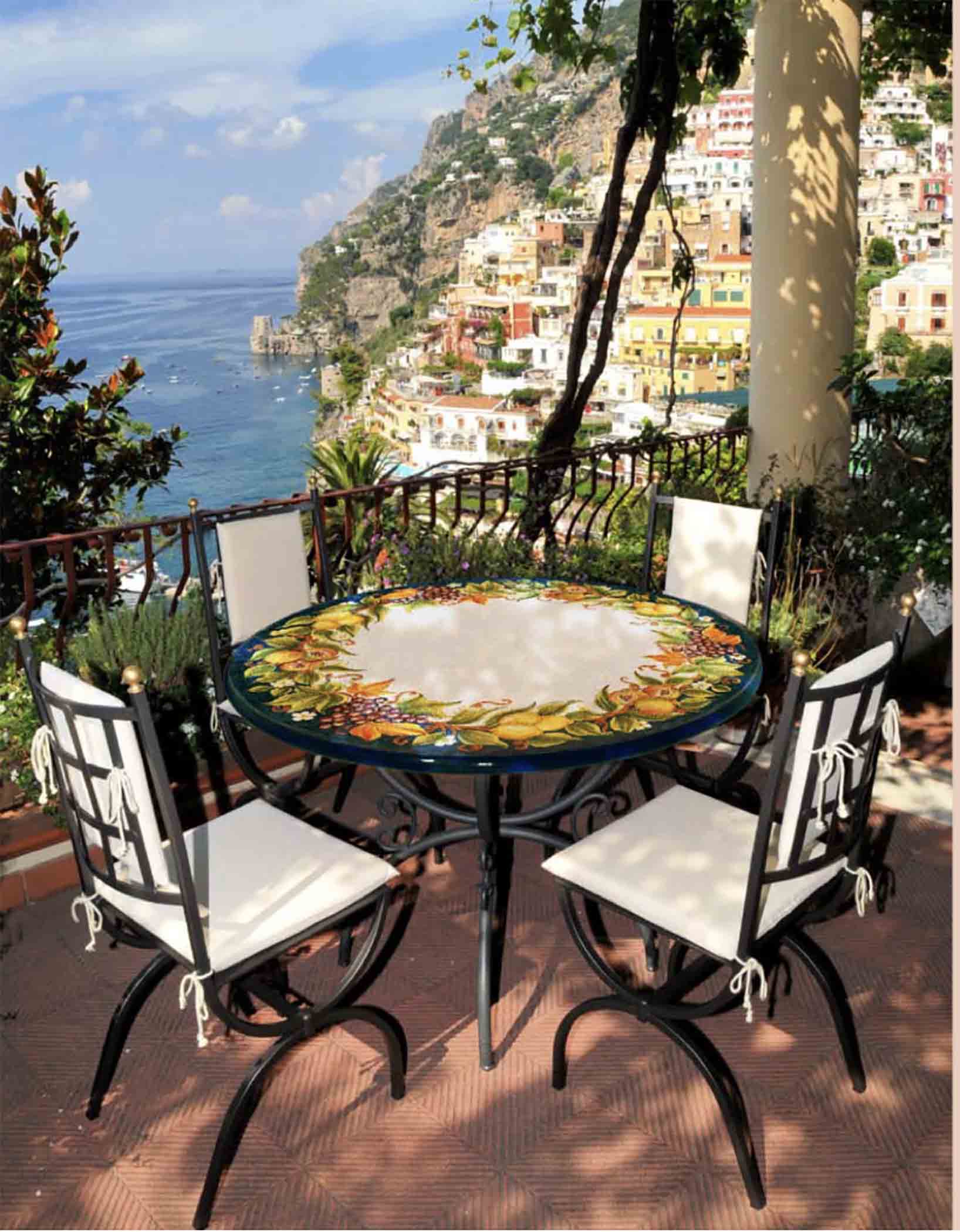 Italian hand-painted ceramic glazed round volcanic stone table in Ravello Frutteto mixed fruit garland design with a classic wrought iron base